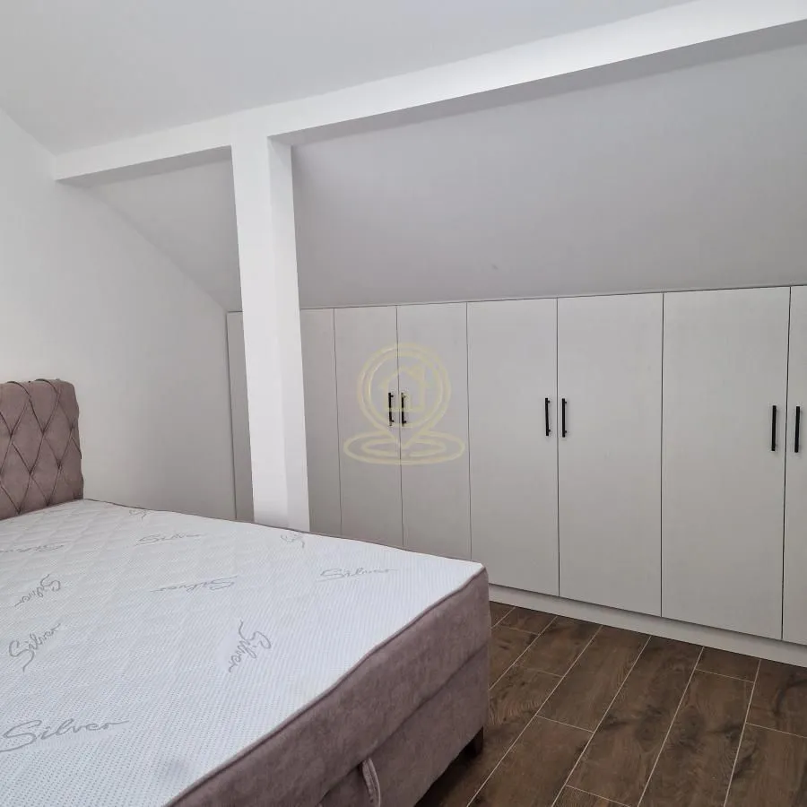 Bedroom with a double bed and a fitted wardrobe under the sloping ceiling.