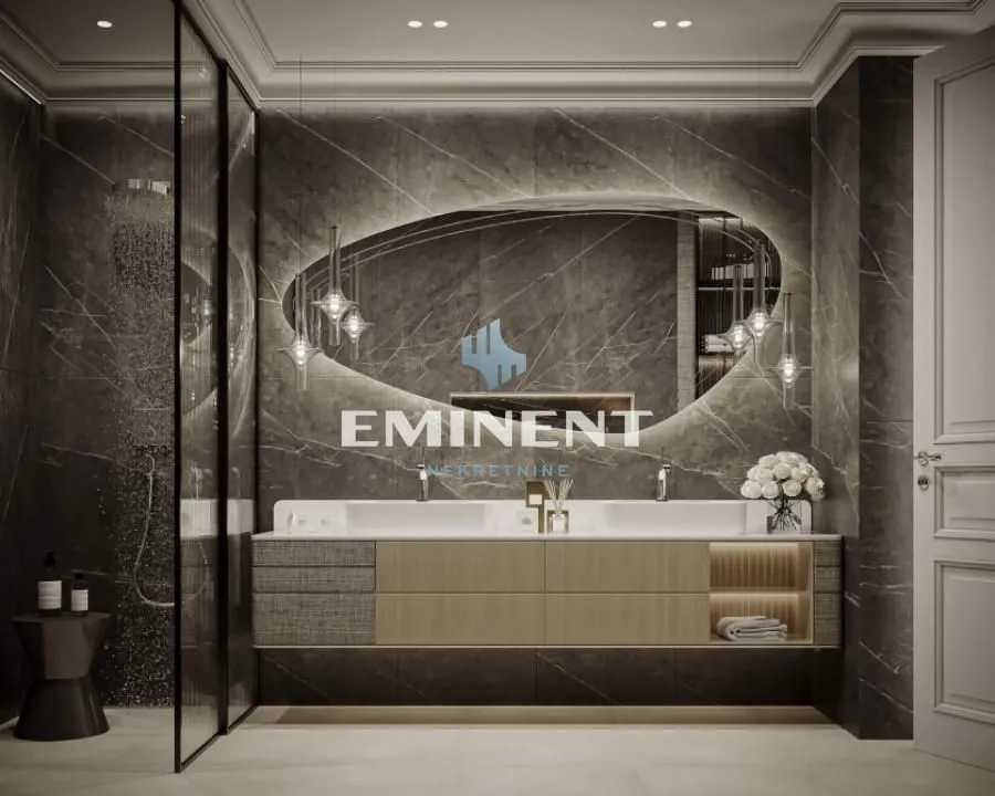 Modern bathroom with a double vanity, large illuminated mirror, and a walk-in shower.