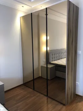 Modern three-door wardrobe with mirrors in a bedroom. - image 20