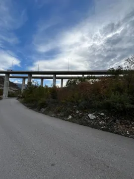Asfaltni put koji vodi prema velikom betonskom vijaduktu u prirodi. - image 2