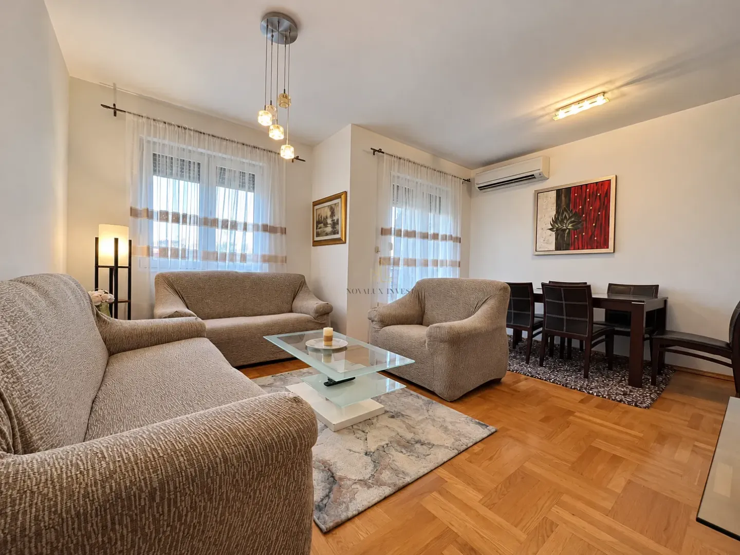 Spacious living room with sofa set, coffee table, and dining table.