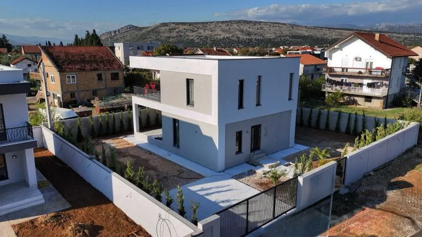 Pogled iz vazduha na modernu dvospratnu kuću sa ograđenim dvoriijem.