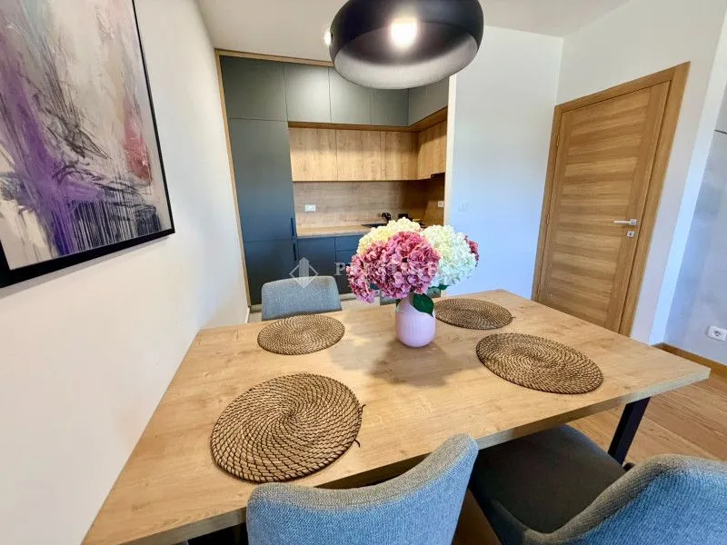 Dining area with a wooden table and chairs, looking towards the kitchen.