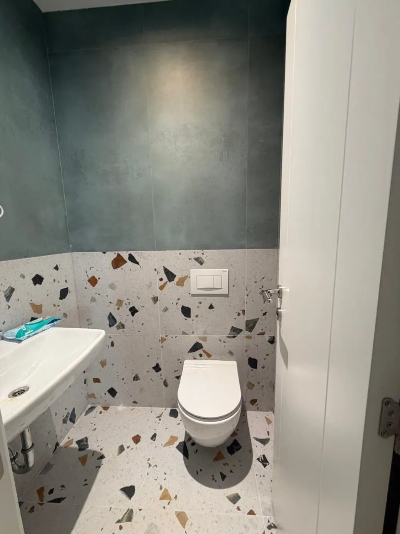 Moderno opremljeno kupatilo sa lavaboom i konzolnom wc šoljom.