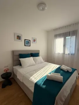 Udobna spavaća soba sa bračnim krevetom, bijelom posteljinom i detaljima u plavoj boji. - image 11