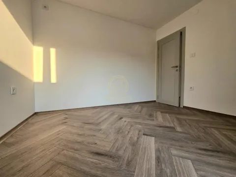 Prazna soba sa laminatom u obliku riblje kosti i zatvorenim vratima. - image 4