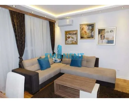Living room with a sectional sofa, coffee table, and wall art. - image 13