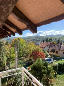 View from the balcony overlooking surrounding greenery and houses. - image 10