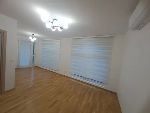 Empty living room with hardwood flooring, large windows and an air conditioner. - image 2