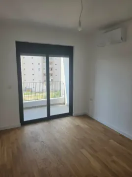 Prazna soba sa drvenim podom, klima-uređajem i izlazom na balkon. - image 8