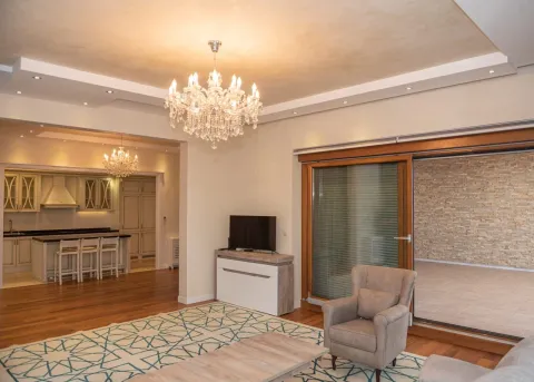 Spacious living room with seating area, fireplace, and view of the terrace, with the kitchen in the background. - image 7
