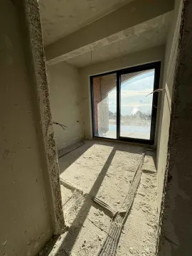 Nepreuređena prostorija u sivoj fazi sa balkonskim vratima i pogledom na more. - image 2