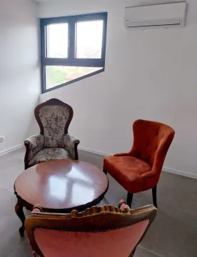 Living room with a seating area and an unusual window. - image 7