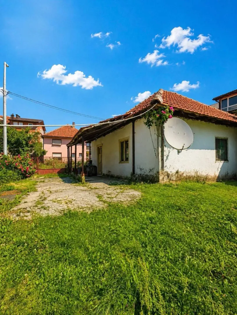 Pogled na dvorište i zadnju stranu kuće sa travnjakom.