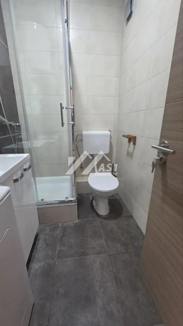 Pogled na moderno opremljeno kupatilo sa tuš kabinom.
