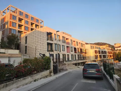 Spoljašnji izgled stambene zgrade u izgradnji sa ulicom i parkiranim automobilom. - image 7