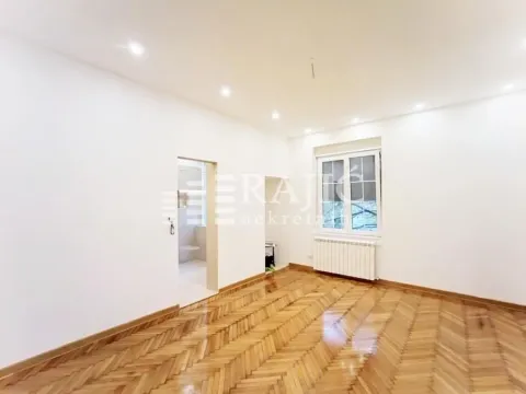 Empty room with parquet flooring and a window. - image 6