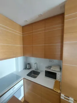 Small wooden kitchen with a built-in sink and appliances. - image 14