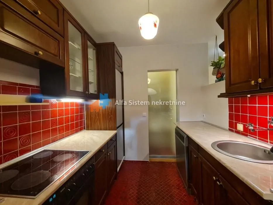 Traditional kitchen with dark wooden cabinets and red tiles.