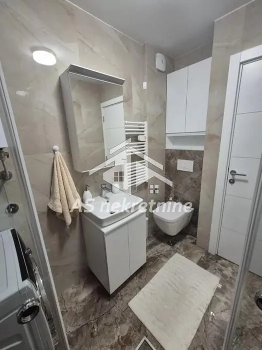 A modern equipped bathroom with a washbasin, cabinet, and toilet.