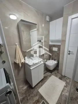 A modern equipped bathroom with a washbasin, cabinet, and toilet. - image 24