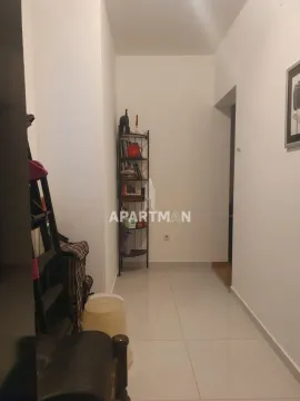 Hodnik sa policom za knjige i svetlim pločicama na podu. - image 3