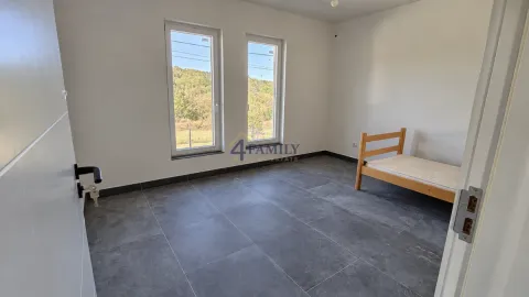 Empty room with grey tiles and a wooden bed. - image 16