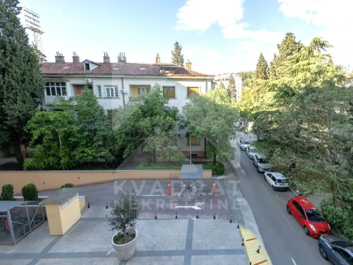 Pogled sa terase na zgradu i okolnu ulicu sa zelenilom.