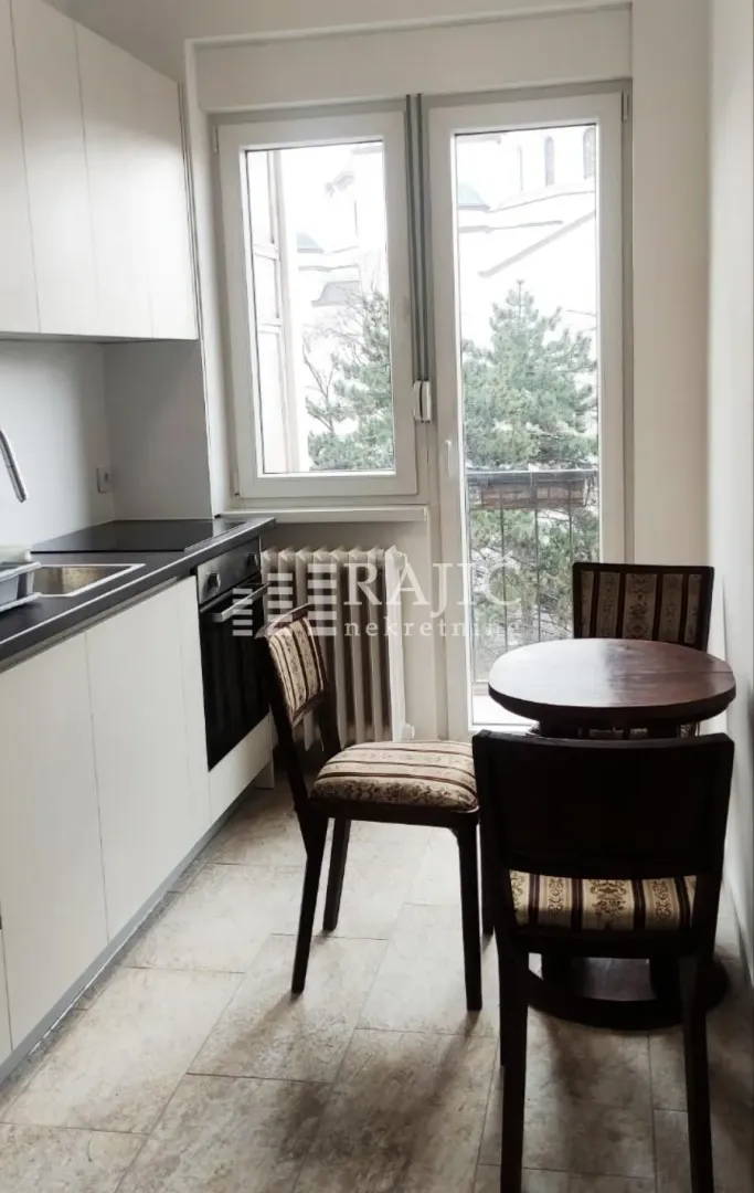 Smaller kitchen with a dining table and balcony access.