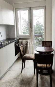 Smaller kitchen with a dining table and balcony access. - image 2