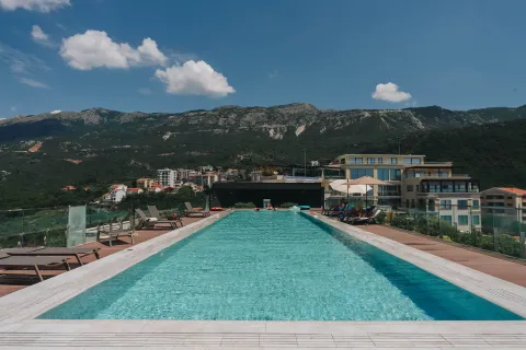 Outdoor swimming pool with sun loungers and mountain views. - image 17