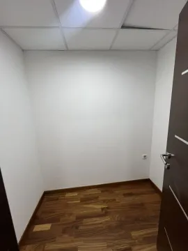 A small empty room with wooden flooring and white walls. - image 9