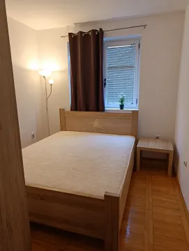 Namještena spavaća soba sa bračnim krevetom, noćnim stočićem i prozorom. - image 6