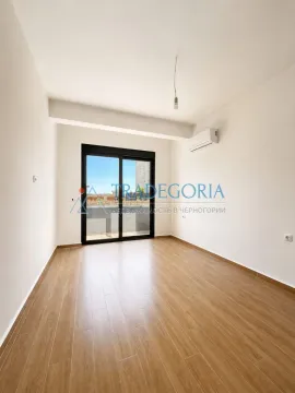 Prazna soba sa bijelim zidovima, drvenim podom i izlazom na terasu. - image 5
