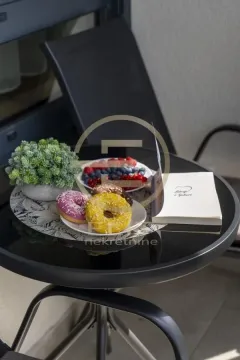 Stočić na terasi sa voćem, krofnama i knjigom. - image 18
