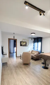 Living room with sofa, TV unit, and dining table. - image 2