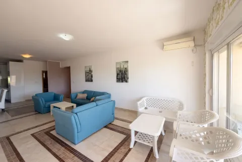 Spacious living room with blue sofas and a dining area in the background. - image 3