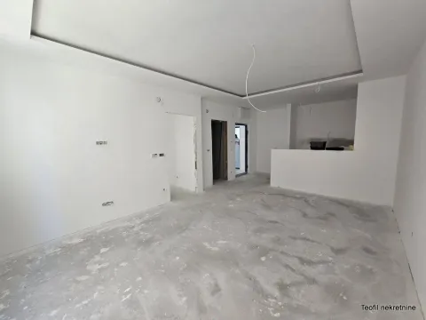 Prazna prostorija u neuređenom stanu sa belim zidovima i spuštenim plafonom. - image 3