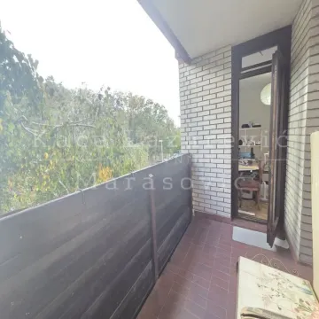 Manji popločani balkon sa drvenom ogradom i pogledom na zelenilo. - image 6