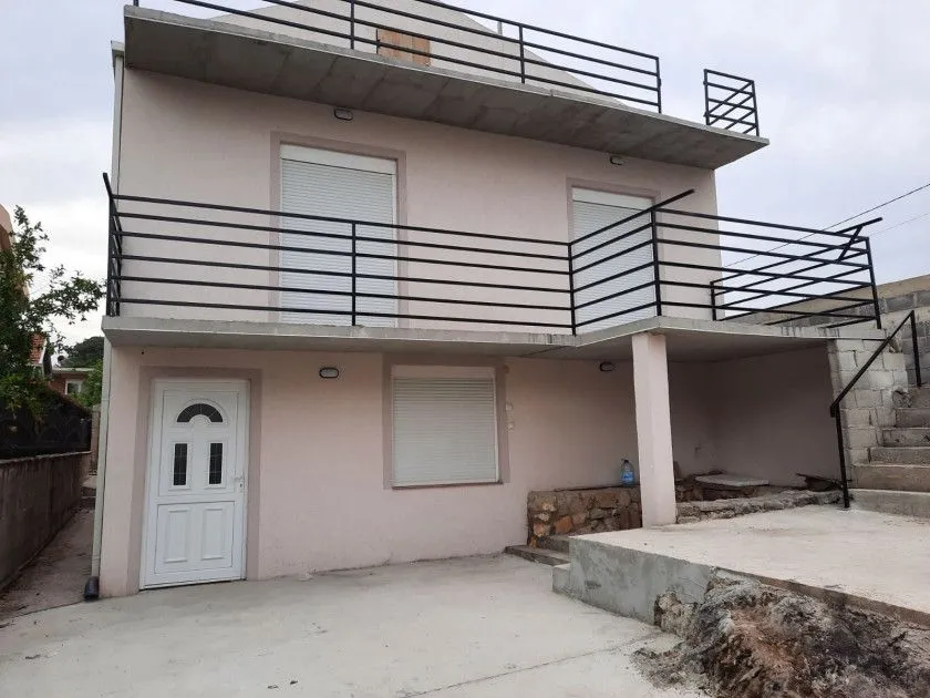 Exterior view of the house with a yard and terraces.
