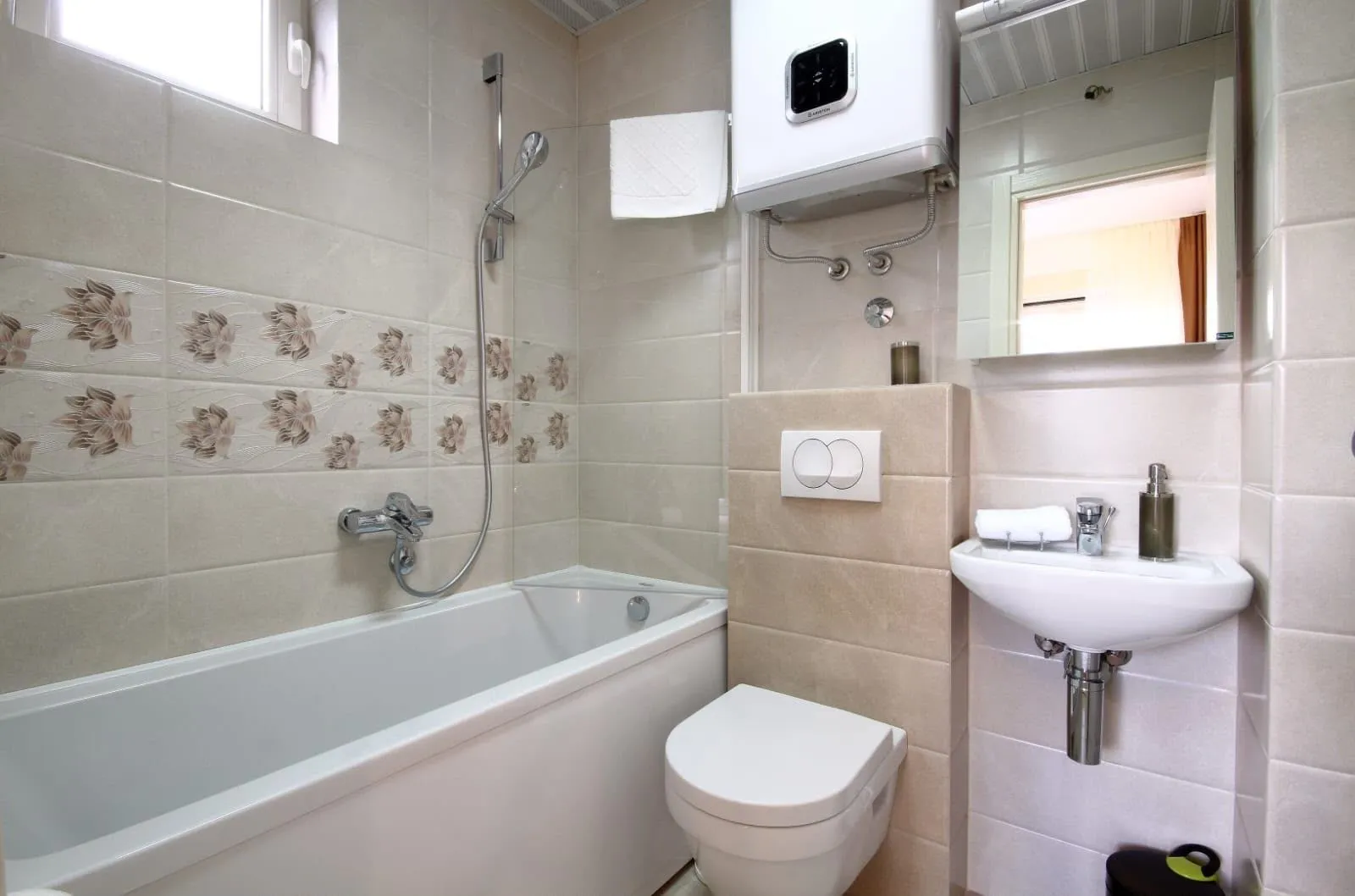 Small bathroom with bathtub, toilet and washbasin in beige tones.