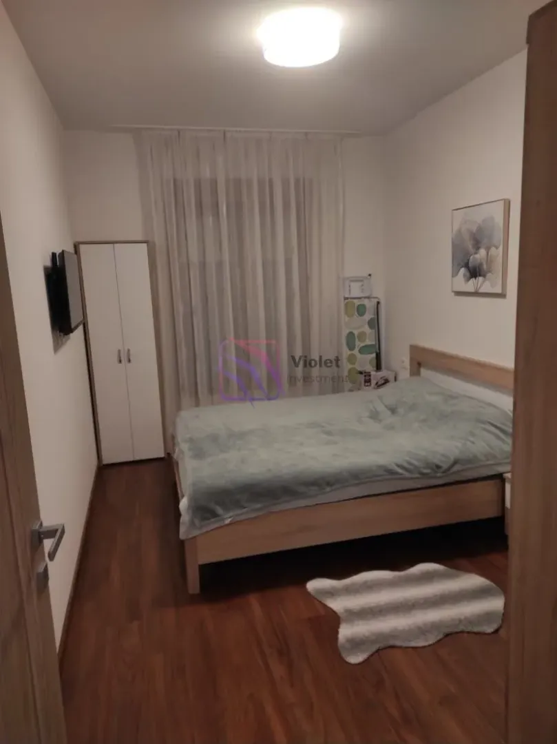 Small bedroom with a double bed, wardrobe, and a window with curtains.