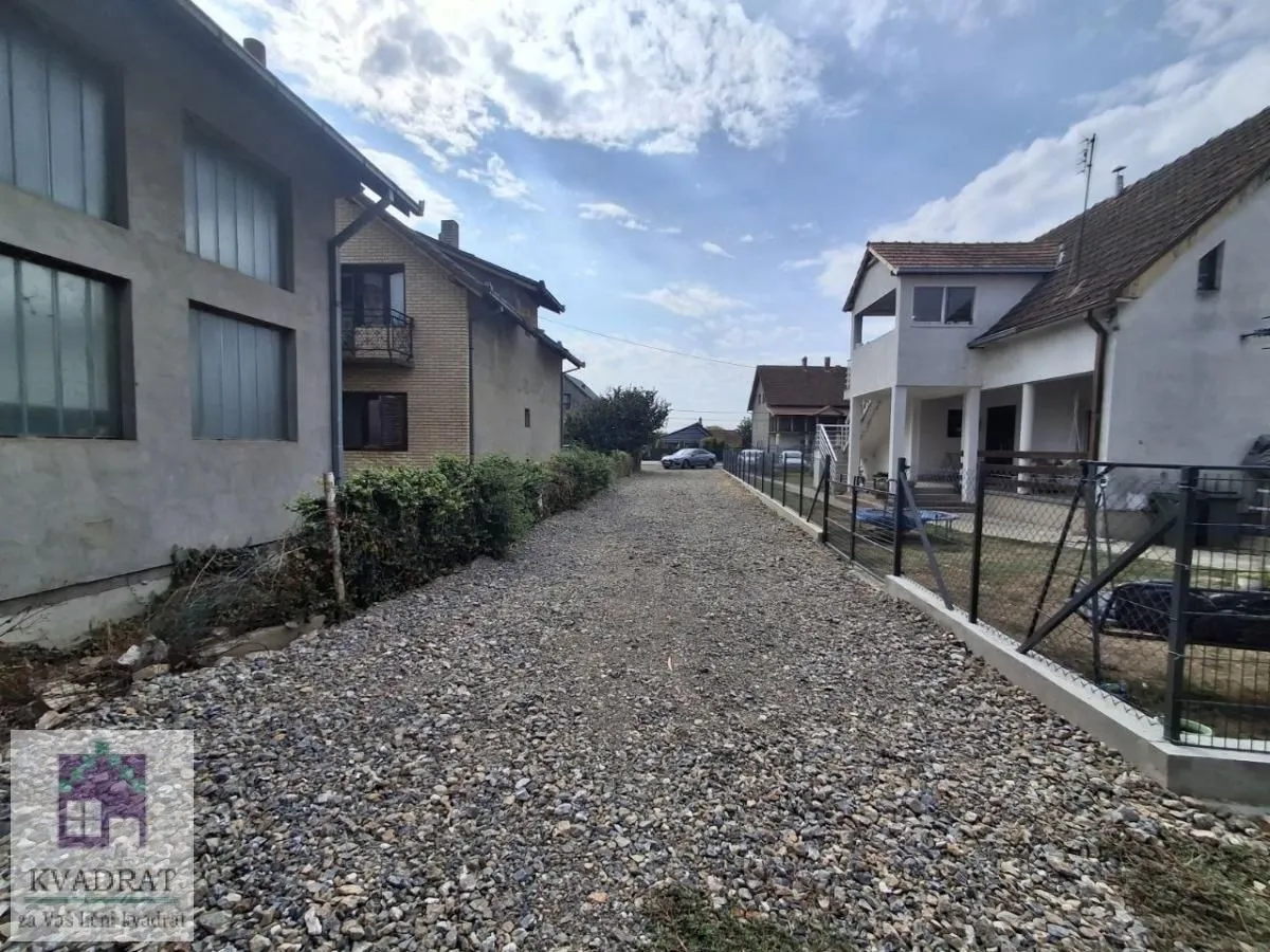 Pogled na prilaz i dvorište ispred kuće sa šljunkovitom podlogom.