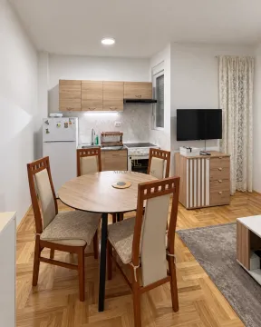 Small kitchen with a dining table and chairs integrated into the living room area. - image 3