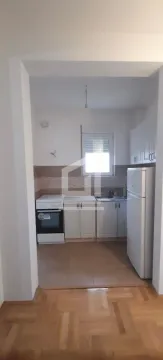 Manja kuhinja sa bijelim elementima, šporetom i frižiderom. - image 4