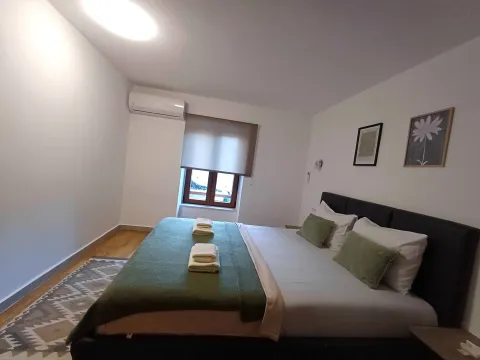 Uređena spavaća soba sa bračnim krevetom, klima uređajem i prozorom. - image 10