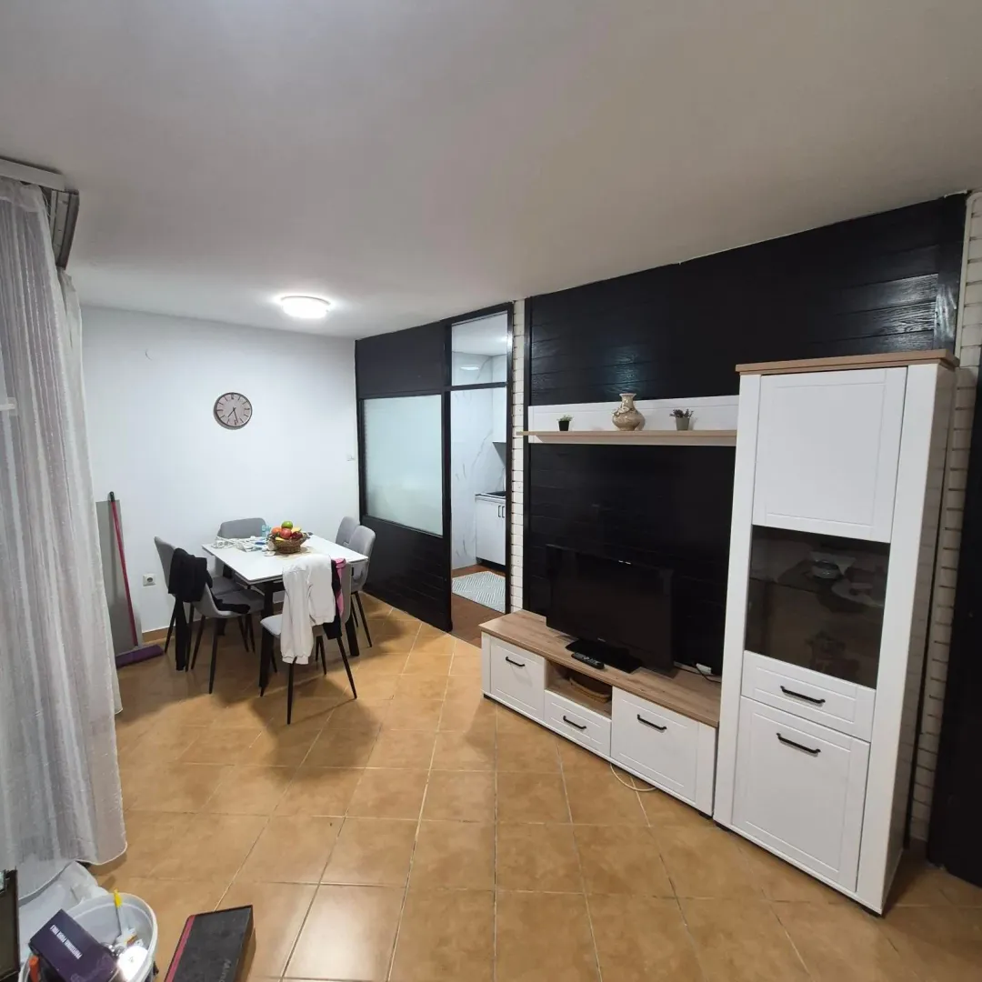 Living room with dining area and TV unit.