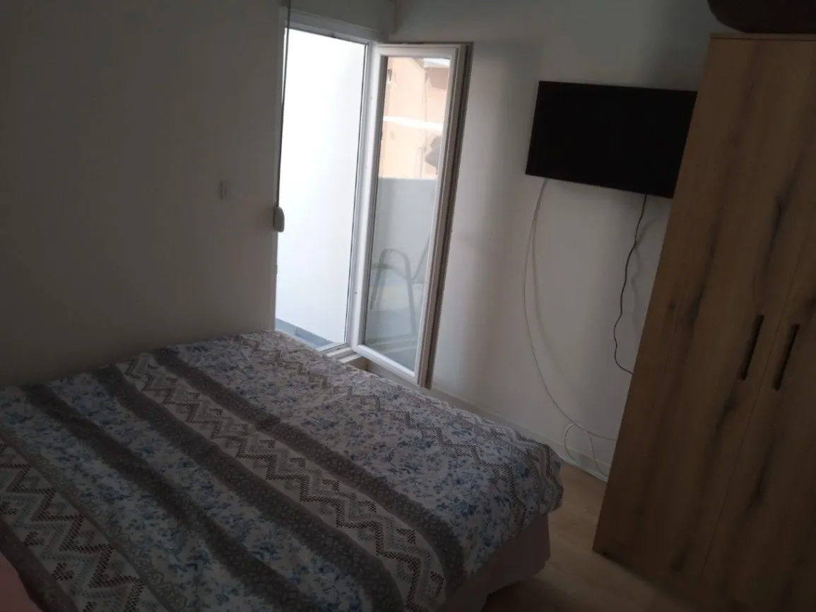 Furnished bedroom with a double bed, wardrobe, and terrace access.