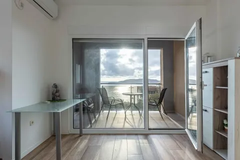 View of the terrace and the sea through an open balcony door. - image 9