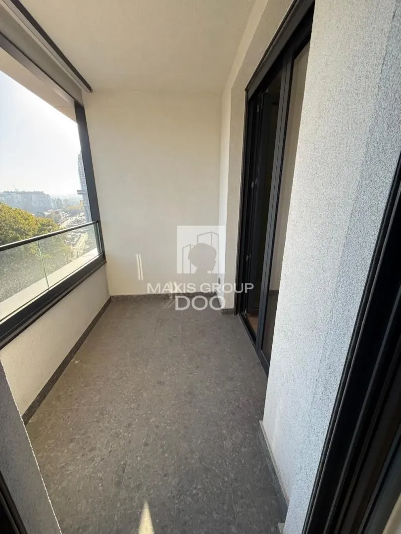 Unfurnished balcony space with a glass railing and a view of the surroundings.